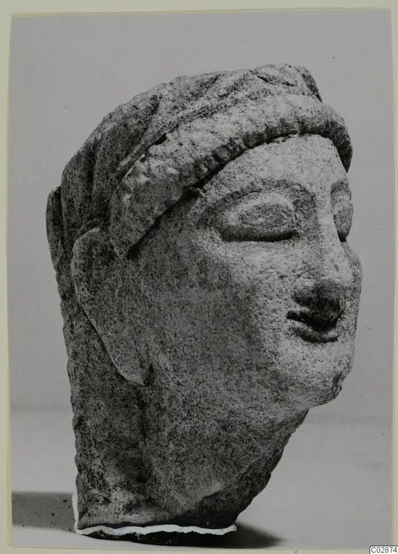Limestone head from Kition, turned to the right, with a band across the forehead and hair falling behind the ears.