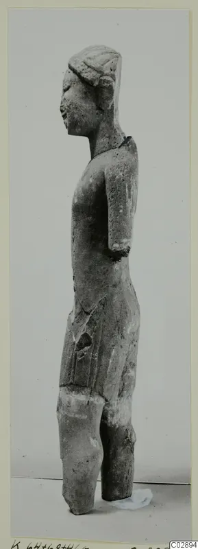 Limestone statue of a standing figure seen in profile, with the lower legs broken