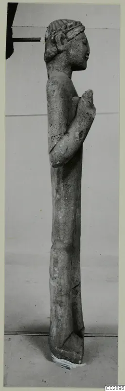 Limestone statue of a standing figure in profile, from Kition, with a hand raised to the chest