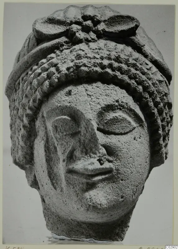 Limestone head fragment from Kition, with large almond-shaped eyes and a tiered headdress.