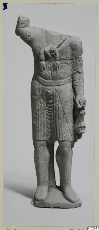 Headless limestone statuette of a standing figure in a belted, pleated garment, from Kition