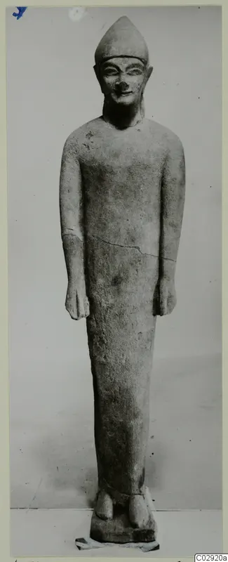 Limestone statue from Kition of a standing figure wearing a pointed cap