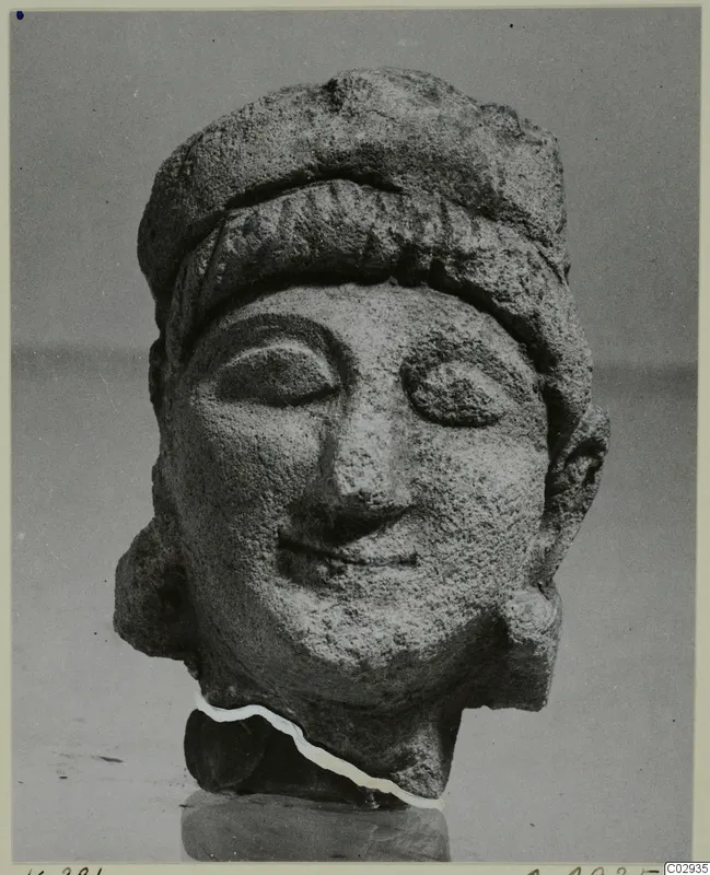 Limestone Cypro-Greek II head (K. 381 C.M.), a carved stone head with a close-fitting cap.