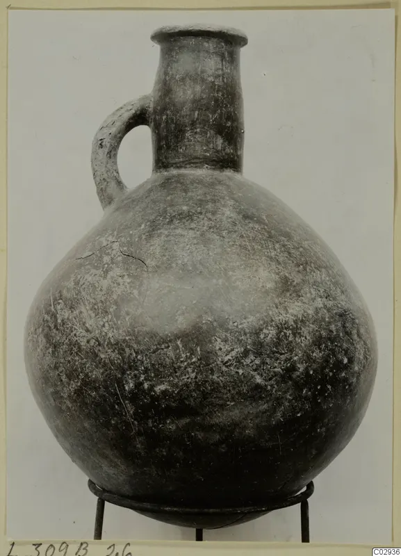 Red Polished III jug from Lapithos with one handle, standing on a wire stand
