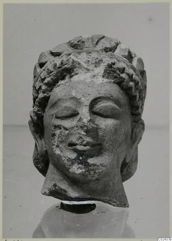 Limestone head sculpture from Kition with closed eyes, curled hair and a worn nose and chin