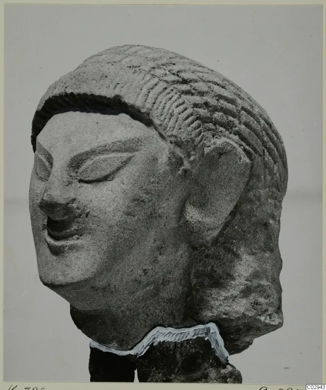 Limestone head statuette from Kition, shown in three-quarter view against a plain grey background