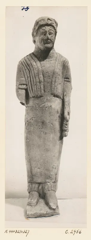 Limestone statue of a standing bearded figure in a long robe with a draped shawl, from Kition