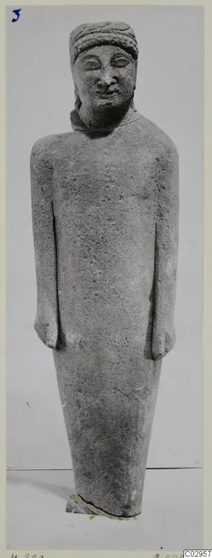 Grey limestone statue of a standing figure with a band around the head and arms held at its sides
