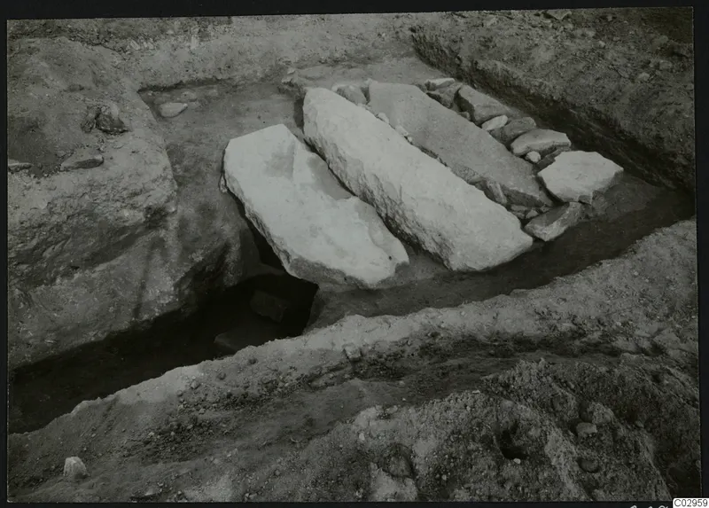 Excavation at Amathus with large pale stone slabs lying in a trench