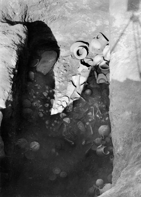Tomb 10 at Amathus, with pottery vessels and sherds lying in situ in a deep excavated cut.