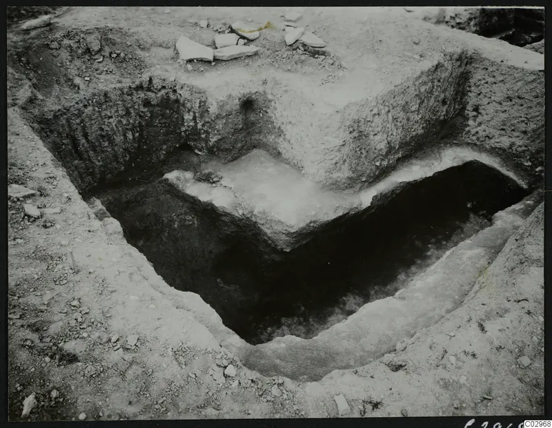 Excavated cutting at Amathus with pale stone blocks and slabs exposed in the trench floor.