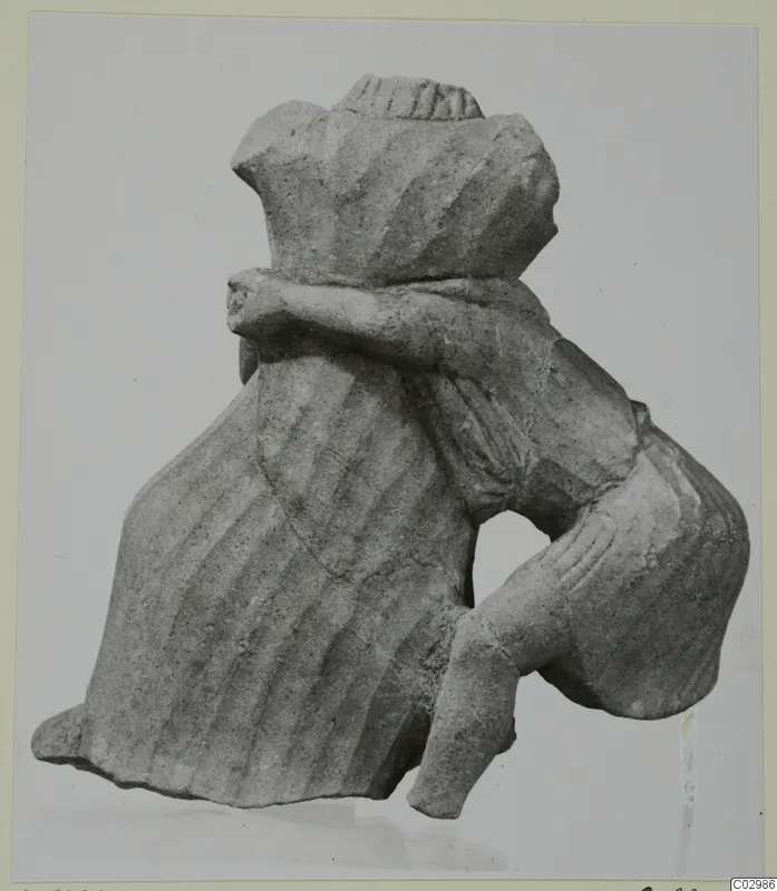 Limestone sculpture of a figure from Vouni, with one arm bent across the body and a ridged head covering