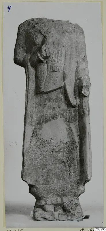 Headless limestone statue of a standing figure from Vouni, photographed frontally against a plain background.