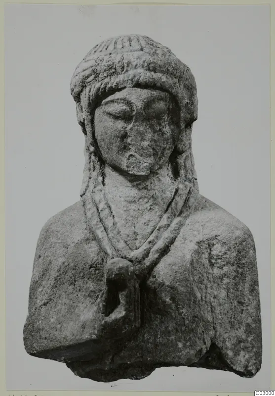 Limestone bust of a figure with a ridged headdress, downcast eyes and a two-strand necklace, from Vouni.