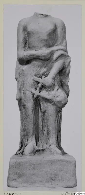 Headless terracotta standing figure with a draped garment on a rectangular base, from Vouni