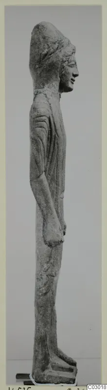 Limestone statue of a standing figure from Vouni, shown in side profile with a tall headdress and arms at its sides