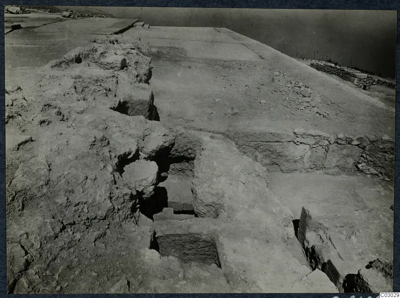 Excavated stone walls and a stepped recess at Vouni palace, with a flat cleared surface beyond