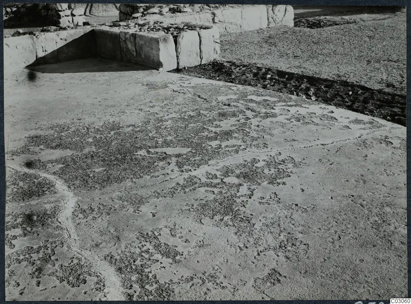 Large squared stone blocks forming a wall at the palace at Vouni, with rubble and worn ground in front