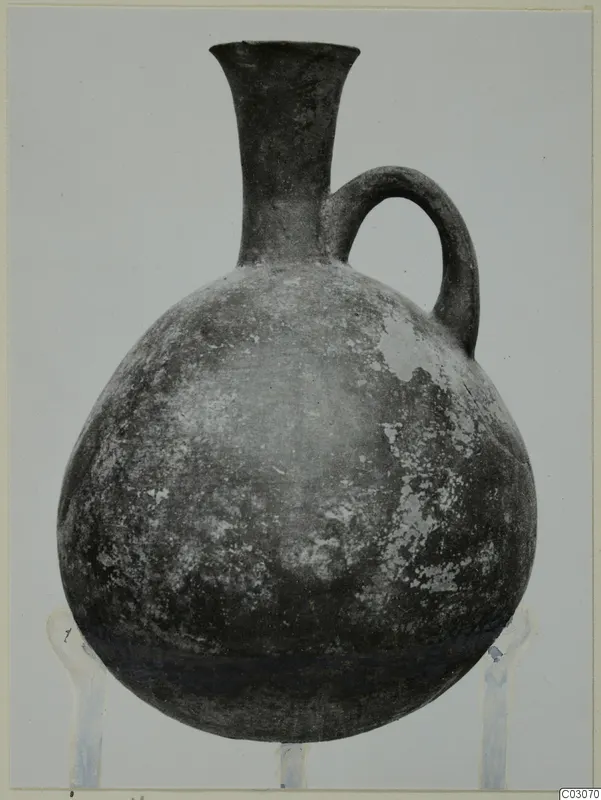 Black Slip Ware jug with a single loop handle and a tall flaring neck