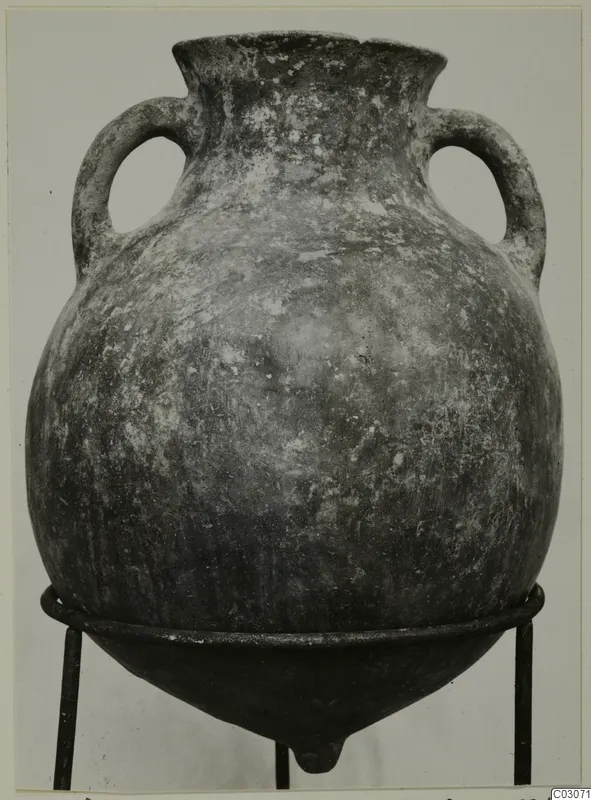 Two-handled Pottery Black Slip Ware jar on a metal stand