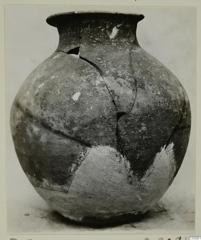 Jar in Plain White Hand-made Ware with a round body and flared rim, cracked and partly restored with light plaster patches
