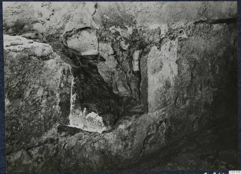 Excavated stone wall at the palace at Vouni, with a dark recess in the masonry