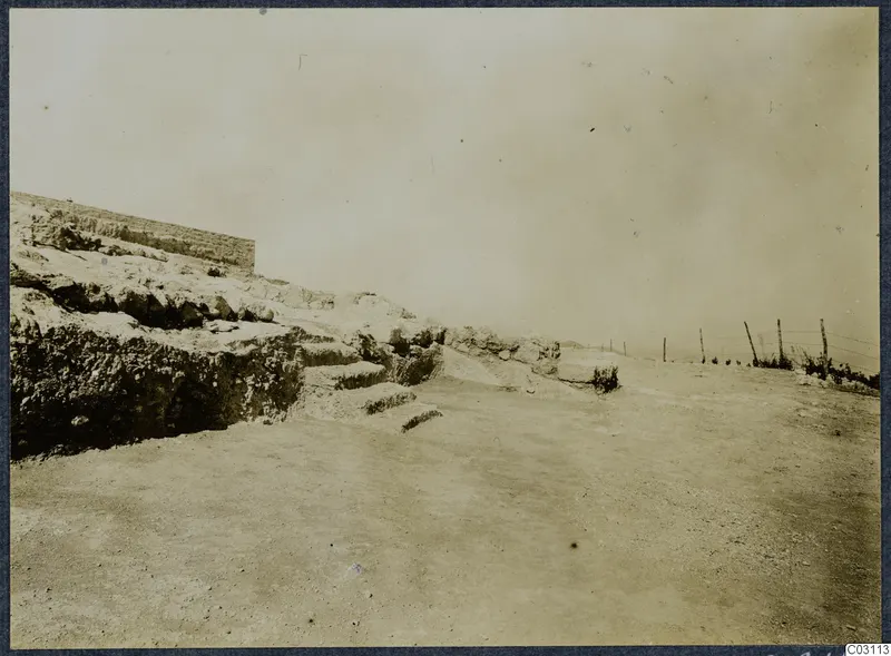 Stone wall and stepped rock ledges at Vouni, with a wire fence on the right.