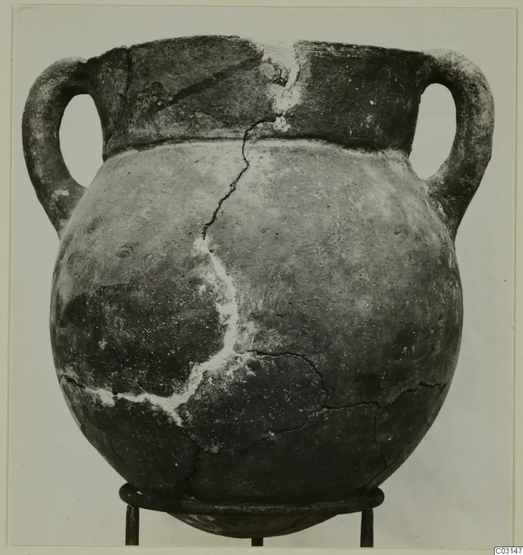 Two-handled globular pottery pot with a wide neck and cracks, shown on a three-legged metal stand