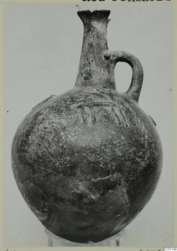 Red Polished I vessel from Lapithos with a tall narrow neck and a single loop handle, shown on a clear stand