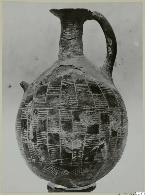 Pottery jug with a tall neck, strap handle and incised hatched rectangles covering the globular body