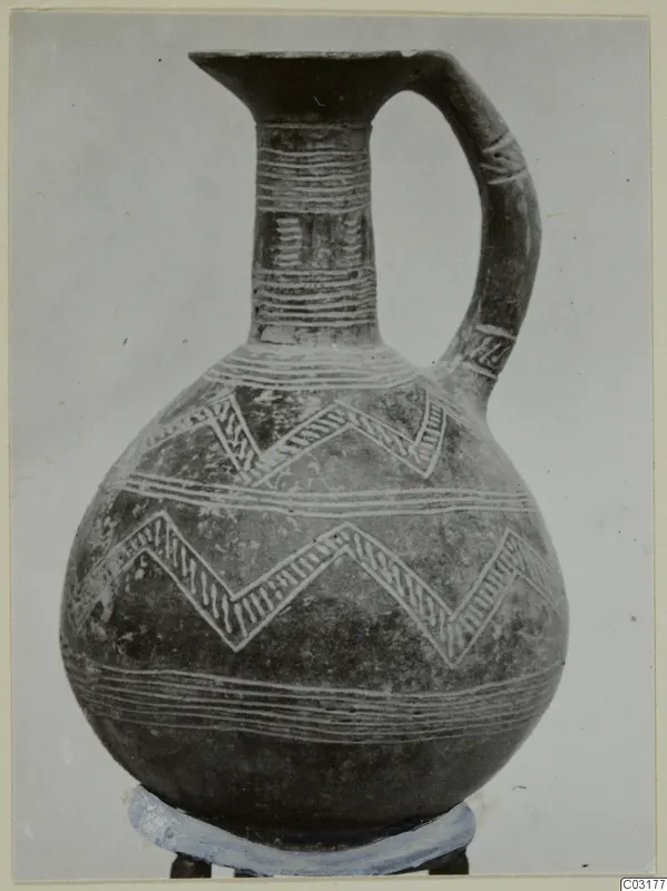 Pottery Red Polished II jug with pale zigzag and horizontal bands, shown on a ring stand against a plain background