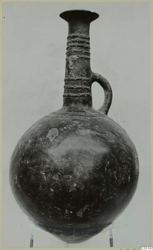 Pottery jug with a globular body, tall neck with raised ribbing, and a single loop handle