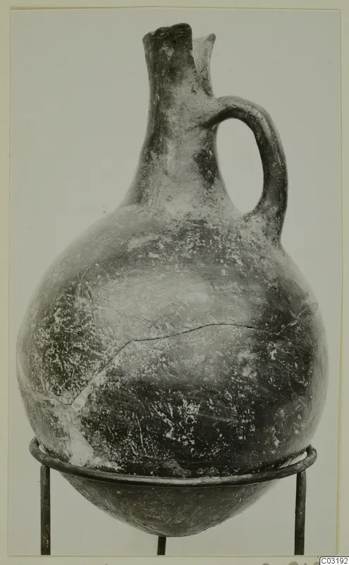 Pottery Red Polished I jug with a single handle and pinched spout, from the Vrysi tou Barba tombs at Lapithos