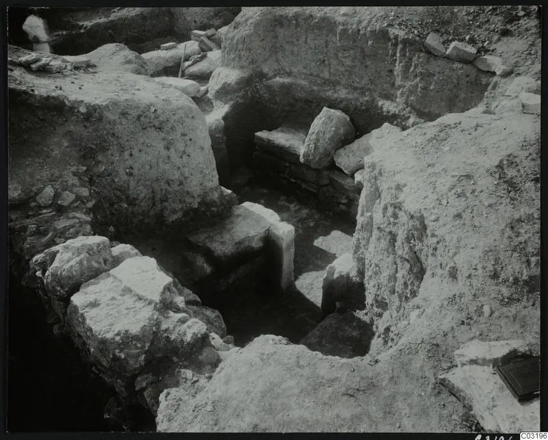 Excavation at Amathus with pale stone blocks and a low stacked stone structure in a trench