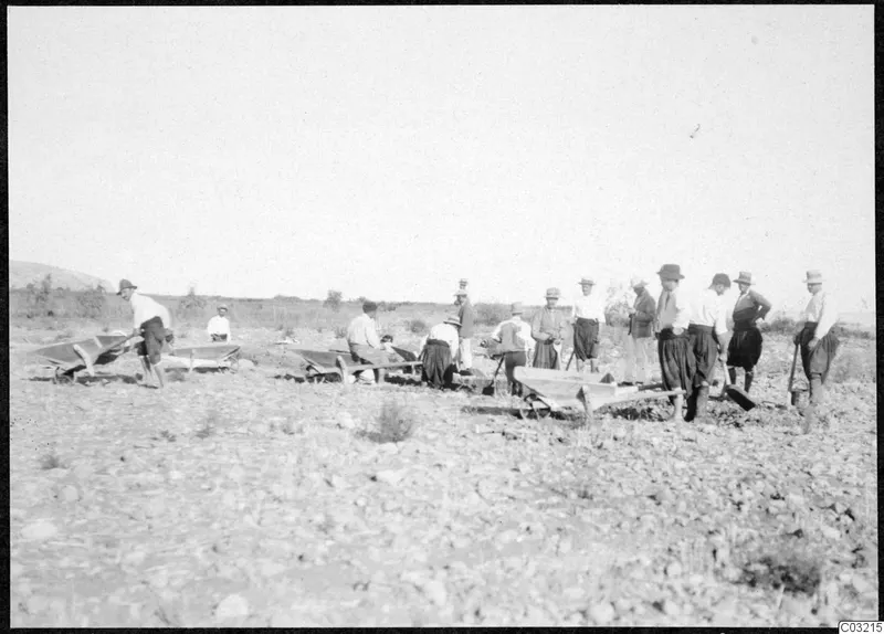 Workers with wheelbarrows digging in a stony field at Soli, Ibrahim's field