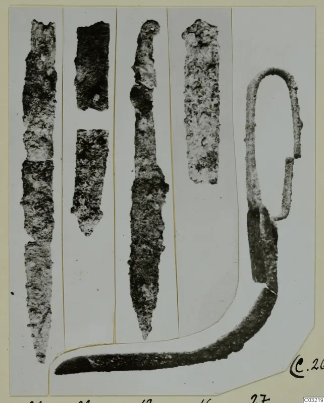 Iron objects from Marion Tomb 44, including long blade-like pieces and a loop-handled tool, shown on a mounted photograph