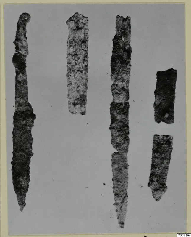 Five corroded iron knives and tool fragments from Marion, laid out on a plain grey ground.