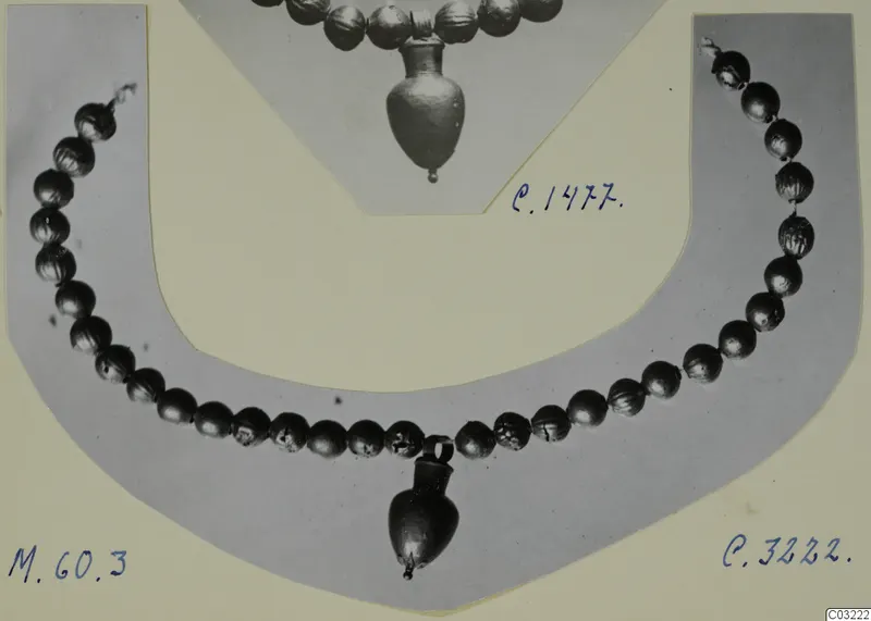Necklace of round beads with a small vessel-shaped pendant, on a grey card mount beside a second necklace photo