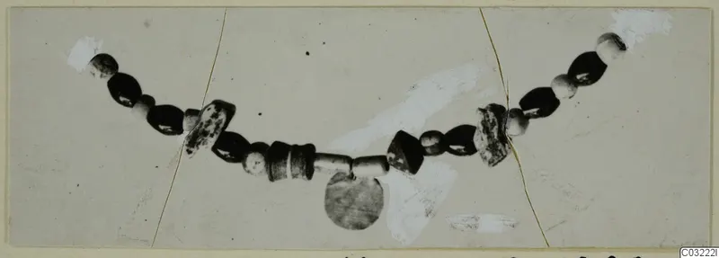 String of dark and pale beads with a disc-shaped pendant, from Marion