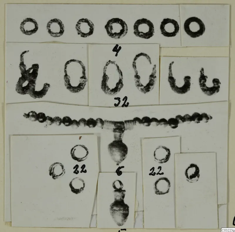 Mounted photographs of rings, a bead strand and pendants from Marion, with handwritten number labels.