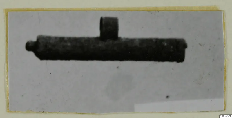 Find photograph of a silver object: a dark tube with a short upright projection and a small knob at one end