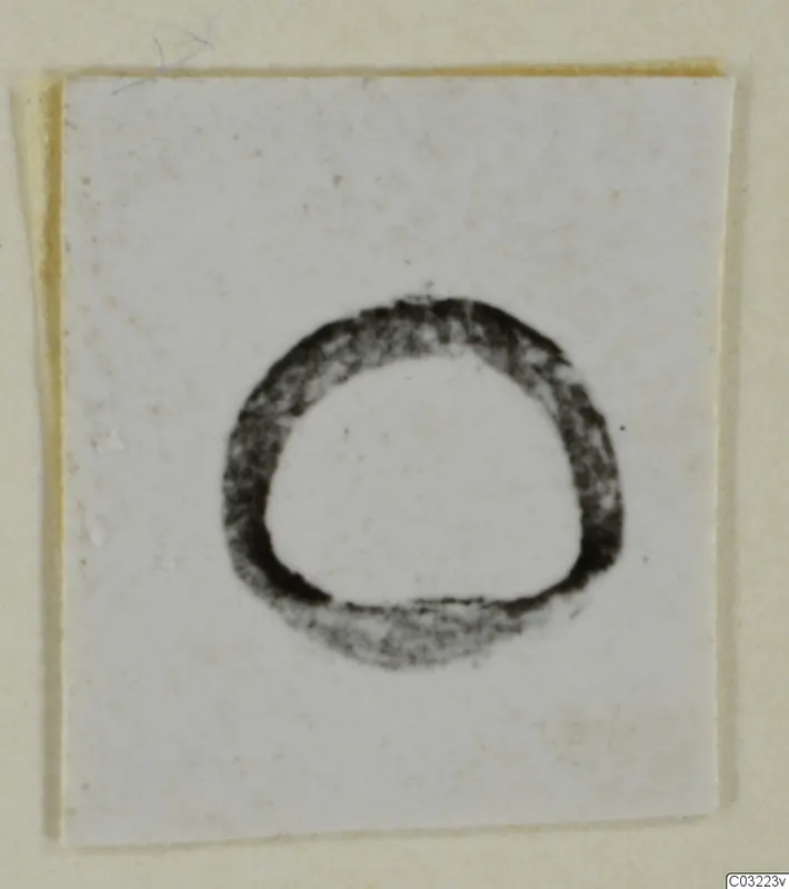 Dark ring-shaped object centred on a pale card, shown as a find of silver