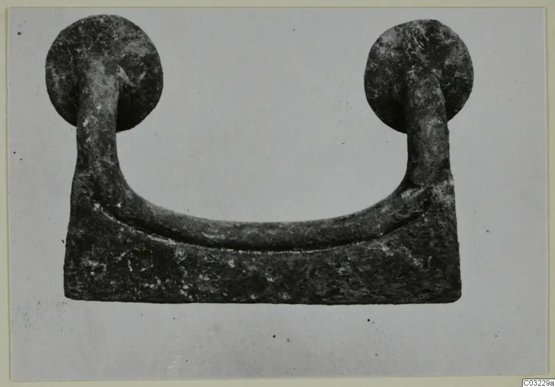 Bronze mounting from Marion: a U-shaped bar with a round knob at each end, on a rectangular base plate