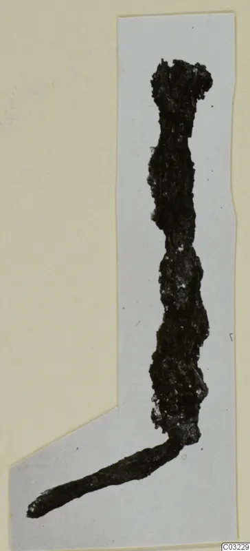 Corroded iron tool fragment, bent at an angle, shown on a grey card mount.