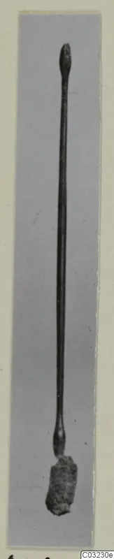 Long slender bronze toilet implement from Marion, Tomb 55, with a knobbed top end and a corroded lump at the base