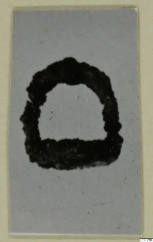 Corroded iron object with a rounded top and flat base, shown on a grey background