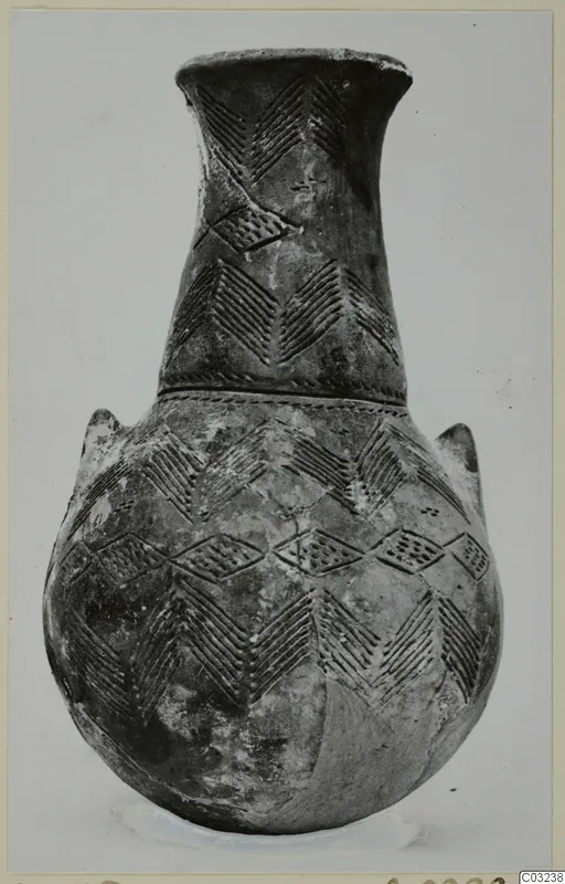 Black Polished pottery vessel with a long neck, two small lugs and incised chevron and lozenge patterns