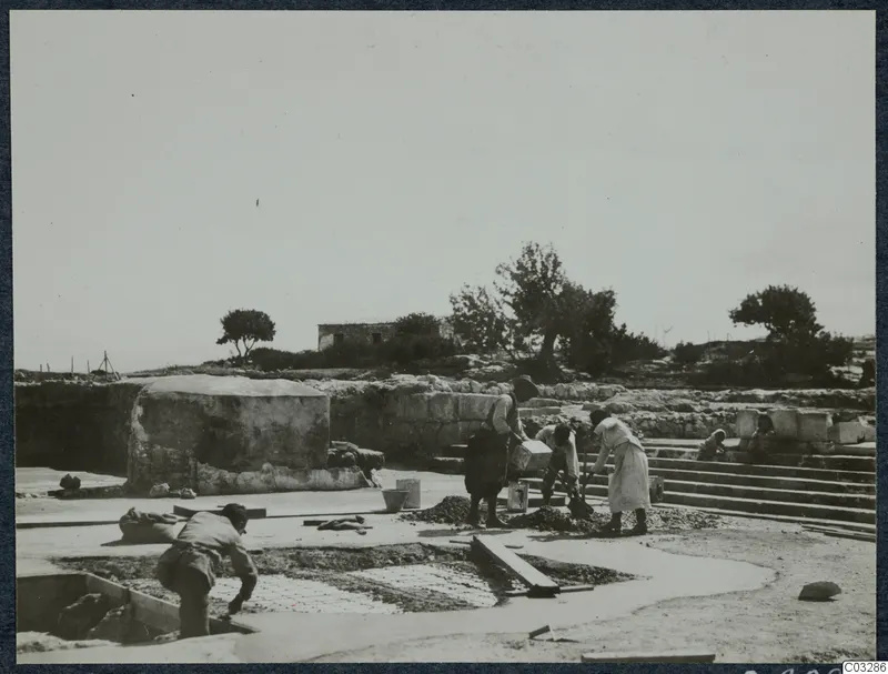 Workers laying a concrete floor over a cistern in Room 47 at Vouni