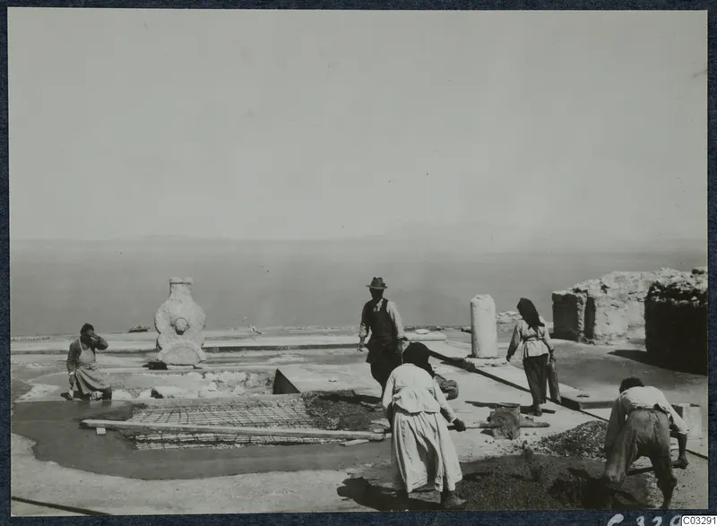 Workers covering the cistern in Room 47 at Vouni Palace with wire mesh and concrete, sea and hills behind