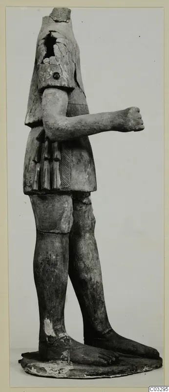 Terracotta statue of a standing figure with the head missing and one arm bent across the body